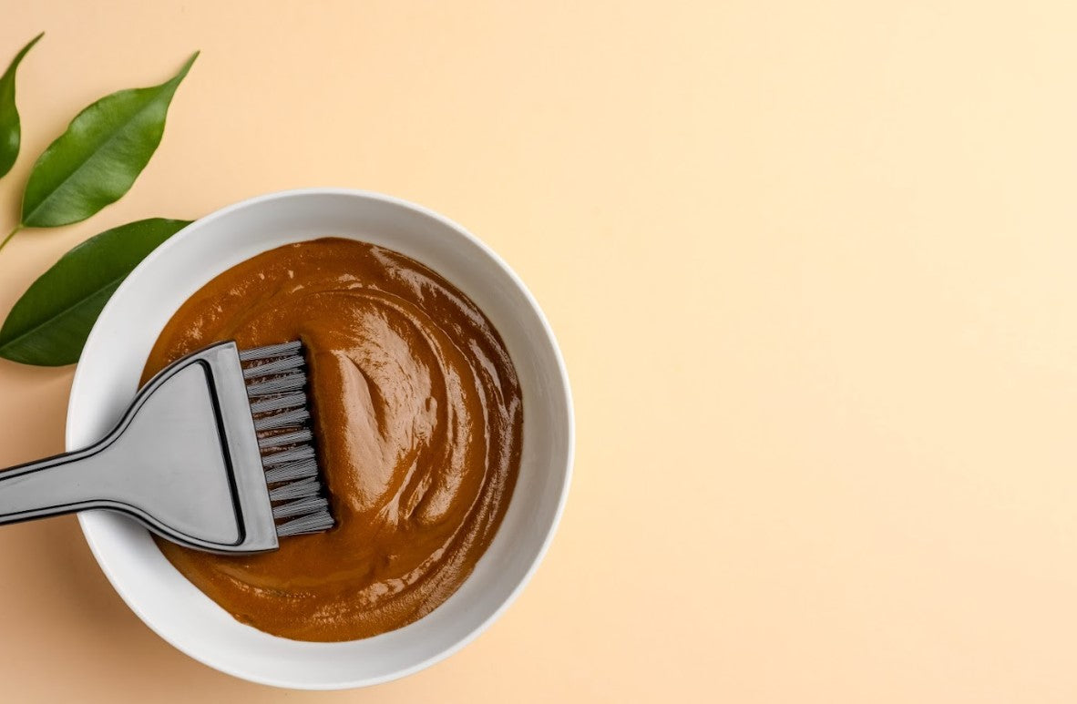 Halal hair dye in a mixing bowl with applicator brush, showcasing smooth natural dye preparation